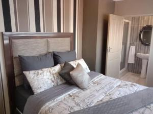 ein Schlafzimmer mit einem großen Bett mit Kissen darauf in der Unterkunft Lemao Properties/guest house in Johannesburg