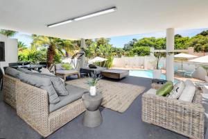 sala de estar con muebles de mimbre y piscina en The Model House, en Ciudad del Cabo