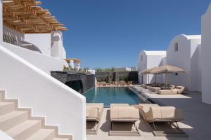 a pool with chaise lounge chairs and a swimming pool at AVAL All Suite Hotel in Mesaria