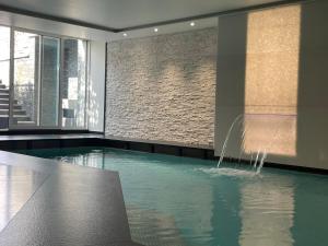 a swimming pool with a fountain in a building at ROSENSUITE La Residenza del rosengarten in Pinzolo +35 photos