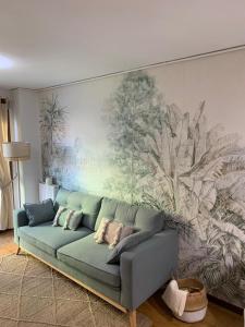 un sofá en una sala de estar con un mural en la pared en El Retiro de Villaviciosa, en Villaviciosa