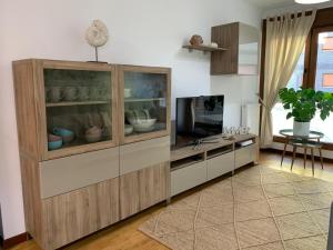 una sala de estar con un gran armario de madera con TV en El Retiro de Villaviciosa, en Villaviciosa