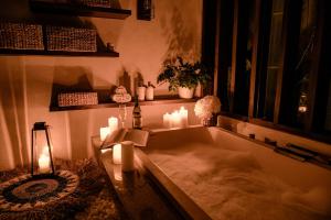 a bath tub with candles in a room at Sunset Palms Beach Villa in Jimbaran