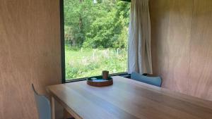 una mesa de madera en una habitación con ventana en Chalet "naast de Schoppe" en Aalten