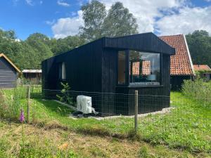 a black house with a window in a yard at Chalet "naast de Schoppe" in Aalten
