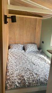 - une chambre avec un lit et une tête de lit en bois dans l'établissement Chalet "naast de Schoppe", à Aalten