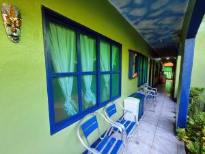 Cabinas Tortuguero Natural في تورتوجويرو: مجموعة من الكراسي على مبنى مع نافذة