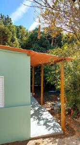 uma pérgola com um telhado laranja sobre uma garagem em Pousada e Camping Daniel em São Roque de Minas