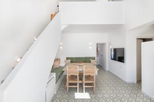 a dining room with a table and a tv at AVAL All Suite in Mesaria