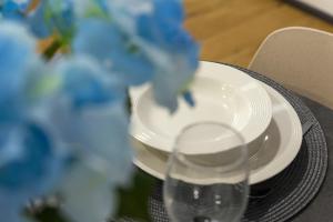 a stack of plates and a glass on a table at Poseidon Apartment in Izola