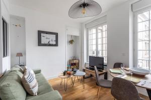 uma sala de estar com um sofá verde e uma mesa em L'ILE AUX MOUETTES - en plein Intra-Muros em Saint Malo