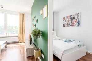 sypialnia z łóżkiem i zieloną ścianą w obiekcie Chill Apartments Mokotow Business Park w Warszawie