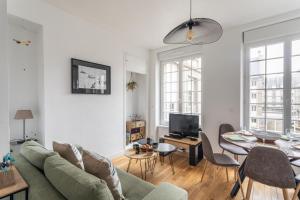 a living room with a green couch and a table at L'ILE AUX MOUETTES - en plein Intra-Muros in Saint Malo