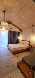 een slaapkamer met een groot bed en 2 kroonluchters bij Costa ANASTASIA_sea view suites in Nea Vrasna