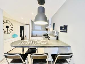 a kitchen with a table and chairs in a room at Le Blue Wave - centre-ville à 700m du LAC in Annecy +34 photos
