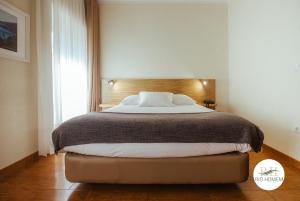 een slaapkamer met een groot bed met een houten hoofdeinde bij Rio Homem in Terras de Bouro