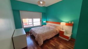 sypialnia z łóżkiem i zieloną ścianą w obiekcie Amplio y luminoso departamento en Belgrano w BuenosAires