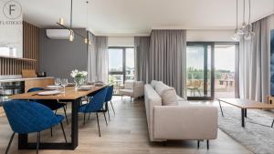 salon ze stołem i niebieskimi krzesłami w obiekcie Flatbook - Yacht Harbor Apartments Sol Marina w mieście Wiślinka