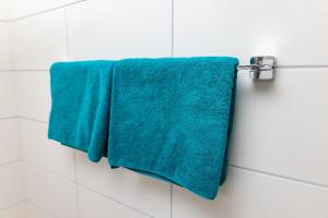 two blue towels hanging on a towel rack in a bathroom at Gasthaus Rössle in Bretzfeld