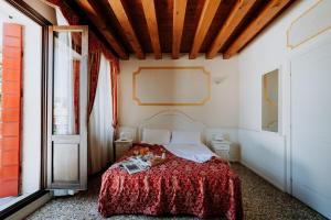 a bedroom with a bed with a red blanket at Hotel Villa Patriarca in Mirano
