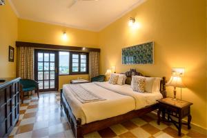 a bedroom with a large bed with yellow walls at Gulaab Niwaas Palace in Pushkar