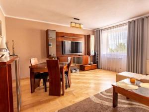 a living room with a table and a dining room at Apartament Jantarowa in Gdynia