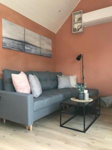ein Wohnzimmer mit einer blauen Couch und einem Tisch in der Unterkunft TINY LIEBE Ostsee Ostsee- bei Wismar in Neuburg