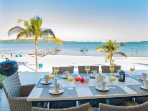 a table with glasses of wine and a view of the beach at Bilene Lodge by Dream Resorts in Vila Praia Do Bilene