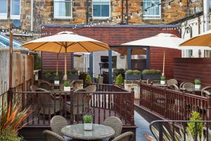 a patio with tables and chairs and umbrellas at Hotel Du Vin, St Andrews in St. Andrews