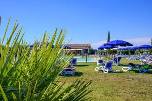 a group of chairs and umbrellas near a pool at Residenza Principina in Principina Terra