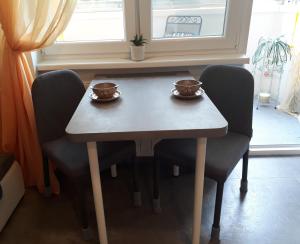 a table and chairs with two cups on top of it at Garsonka Ostrava in Ostrava