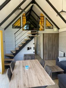 ein Esszimmer mit einem Tisch und einer Treppe in der Unterkunft Chalets Eureka & Bloemenduin Koksijde in Koksijde