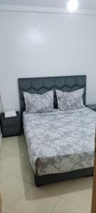 Schlafzimmer mit einem großen Bett mit Kopfteil in der Unterkunft Appartement a louer pour les vacances in Tangier