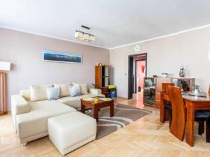 a living room with a white couch and a table at Apartament Jantarowa in Gdynia