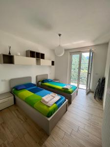 a bedroom with two beds and a large window at Residenza Belvedere in Premana