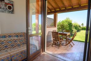 a glass door leading to a patio with a table and chairs at Residenza Principina in Principina Terra