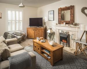 a living room with a couch and a fireplace at Camber Beach House in Camber