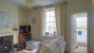 a living room with a couch and a fireplace at Coastguards Lantern in Camber