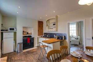a kitchen with white appliances and a table and chairs at Coastguards Lantern in Camber