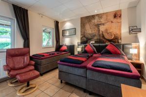 a bedroom with a bed and a couch and a chair at Land-Hotel Zum Schwan, Garni E-Ladestationen, Nähe Phantasialand Nähe Palmenparadies Euskirchen in Weilerswist