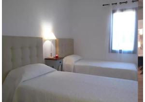 Habitación de hotel con 2 camas y ventana en Anahi Homes Corralejo - Villa Codeso 5, en La Oliva