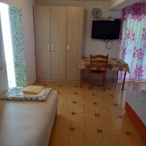 Zimmer mit einem Bett, einem Tisch und einem TV in der Unterkunft Bugenvilija in Budva