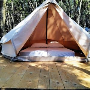 uma cama numa tenda num deque de madeira em Robinzon kamp Val Kavran em Kavran