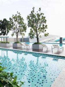 a swimming pool with chairs and trees in a building at Homestay Shah Alam in Shah Alam