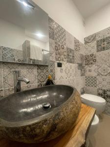 y baño con lavabo de piedra grande y aseo. en B&B Il Cuore del Borgo, en Papasidero
