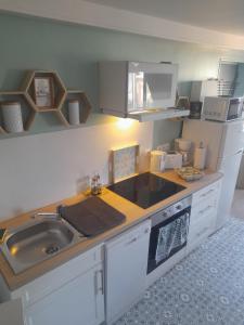 a kitchen with a sink and a counter top at Le diepplex de Sébelle in Dieppe