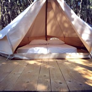 uma cama numa tenda de lona com piso em madeira em Robinzon kamp Val Kavran em Kavran