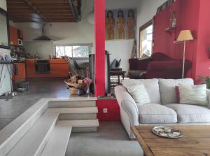 a living room with a white couch and red walls at Tressan:La Calade, maison d'artiste in Tressan