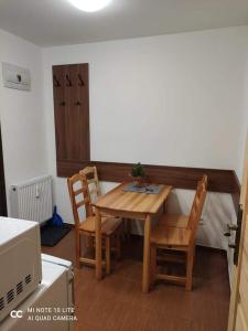 małą kuchnię z drewnianym stołem i krzesłami w obiekcie Apartmán Na zjazdovke, chata Borovica, Valča w mieście Valča