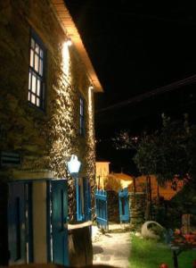 a house with a blue door at night at Refúgio da Estrela in Aguincho
